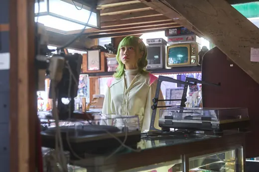 昭和レトロな道具に囲まれた店内に立つアートの子