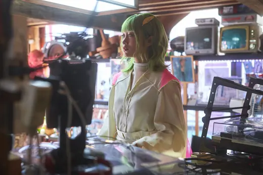 レトロなテレビや道具に囲まれた店内のアートの子